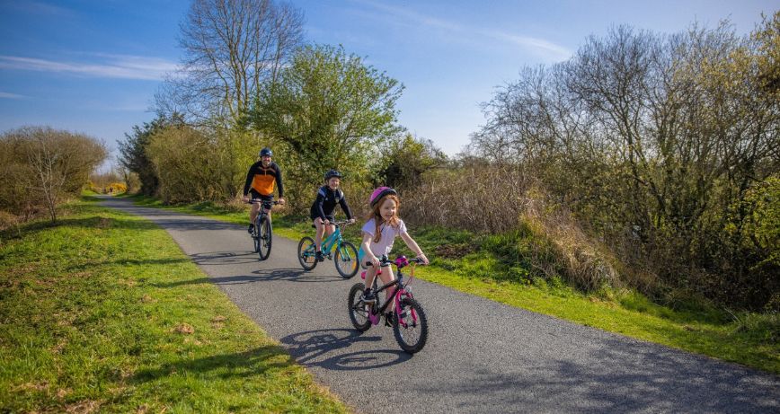 A family on bikes travelling the Comber Greenway